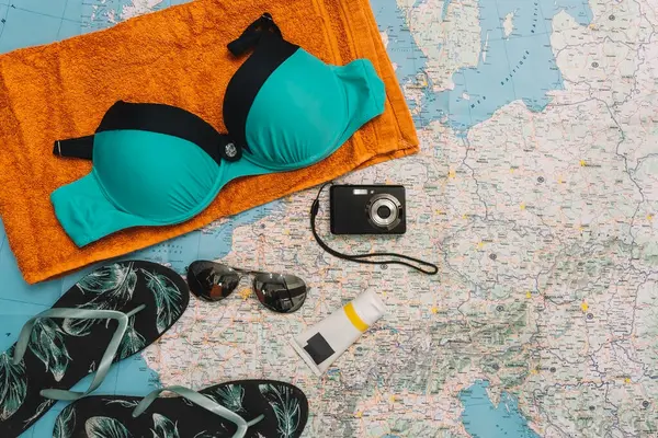 Vista superior objetos de praia. traje de banho, chinelos, óculos de sol e câmera compacta para férias. — Fotografia de Stock