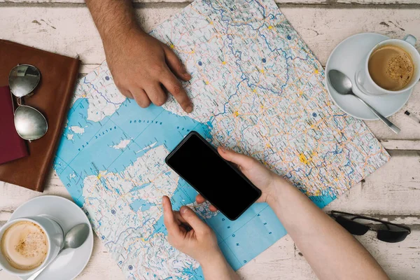 Young couple planning a trip with a map. Holidays, honeymoon. Top view. planning a trip with the help of a map. — Foto de Stock