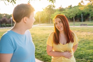 İki harika arkadaş gün batımında şehir parkında sohbet edip, mutlu mesut dolaşıyorlar. Genç kızlar yaz tatilinin tadını çıkarıyorlar. Arkadaşlık ve arkadaşlık kavramı. Doğal ışık, güneş, yaz