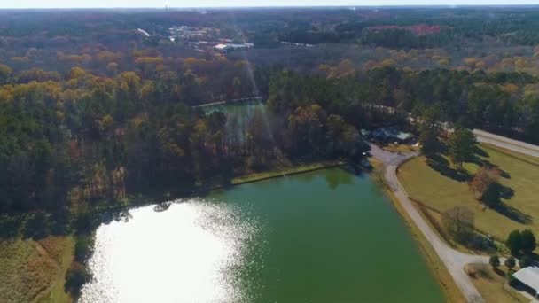 Aerial drone fly over green lake with sun shadow on the left side of the lake. — Stock Video