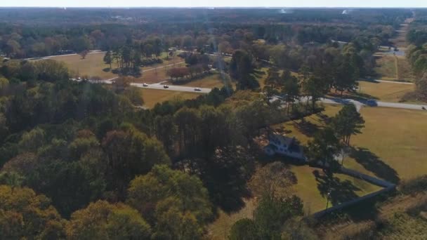 Flygdrönare flyger över en trafikerad väg på landsbygden med träd — Stockvideo