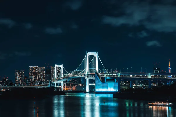 Odaiba 'da gökkuşağı köprüsü, arka planda Tokyo şehir ışıkları