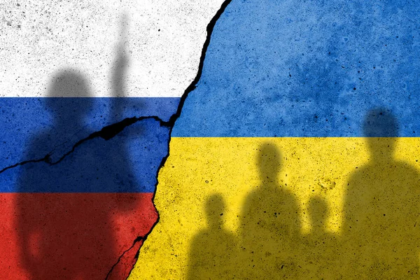 Ukrayna ve Rusya bayrağı beton bir duvarda Ukraynalı siviller ve Rus askerlerinin gölgeleriyle resmedilmiş. Rus askeri saldırısı