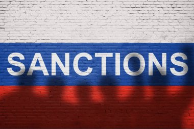Rusya 'nın bayrağı tuğla bir duvara SANCTION sözcüğüyle boyanmış.