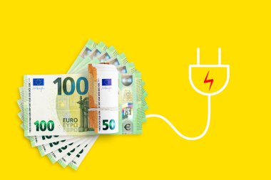 Euro banknotes on a yellow background. Energy crisis and expensive electricity, gas price. Big heating, gas and electricity bill