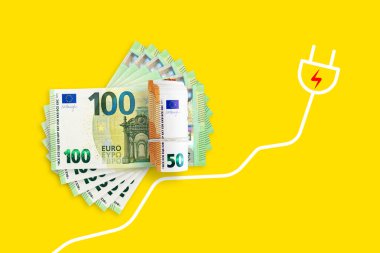 Euro banknotes on a yellow background. Energy crisis and expensive electricity, gas price. Big heating, gas and electricity bill