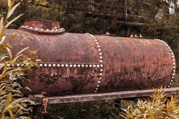 Paslı metal büyük su varili ve beyaz çelik perçinler. 