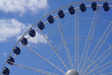       musement park. Attraction under the sky. Blue sky, clouds. Way up. Cabins in the sky. Fun, warm, summer time. Ferris wheel. Joy for children and adults. Fear and excitement                         