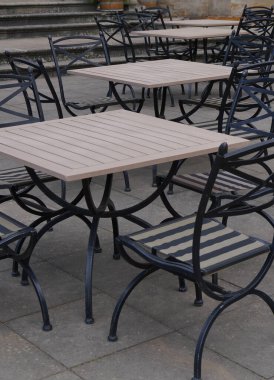 Rows of light tables. Iron black chairs. Early, summer morning in a cafe. Food. Rest in coffee