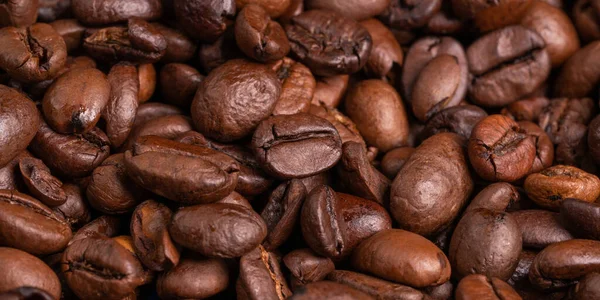 Lots of coffee beans. Fragrant tonic drink. Caffeine, cheerfulness, energy. Good morning. Start of the day. Good mood all day long. Background.