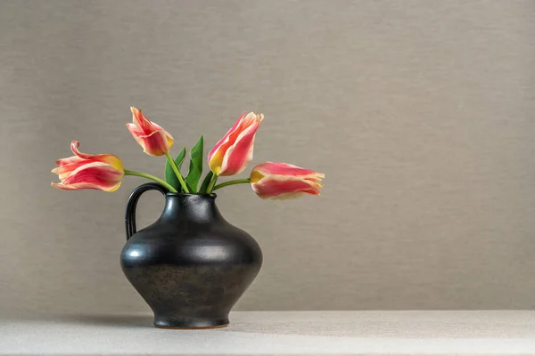 Cuatro Tulipanes Escarlata Una Jarra Barro Gris Sobre Fondo Gris — Foto de Stock