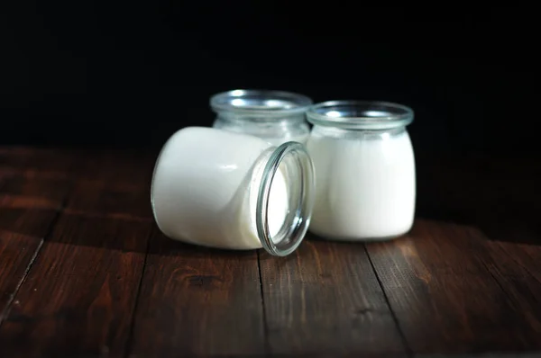Ahşap bir masada kavanozda ev yapımı mayalı yoğurt.