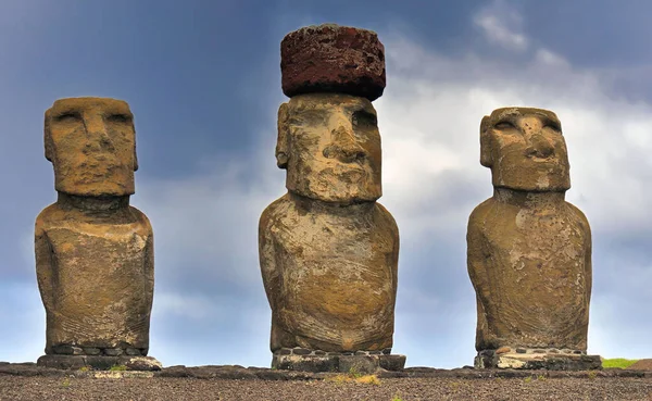 Paskalya Adası 'ndaki mavi bulutlu gökyüzüne karşı üç Moai heykelinin yakın görüntüsü. Şili, Rapa Nui.