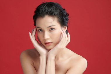 Güzel genç Asyalı kadın, kırmızı arka planda temiz ten, yüz bakımı, yüz bakımı, kozmetoloji, güzellik ve kaplıca, Asyalı kadın portresi..