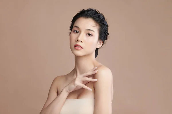 Beautiful young asian woman with clean fresh skin on beige background, Face care, Facial treatment, Cosmetology, beauty and spa, Asian women portrait.