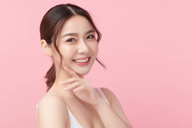 Pembe arka planda temiz tenli güzel Asyalı kadın, yüz bakımı, yüz bakımı, kozmetoloji, güzellik ve kaplıca, Asyalı kadın portresi.