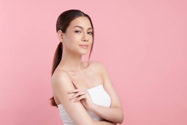 Pembe arka planda temiz tenli güzel Asyalı kadın, yüz bakımı, yüz bakımı, kozmetoloji, güzellik ve kaplıca, Asyalı kadın portresi.
