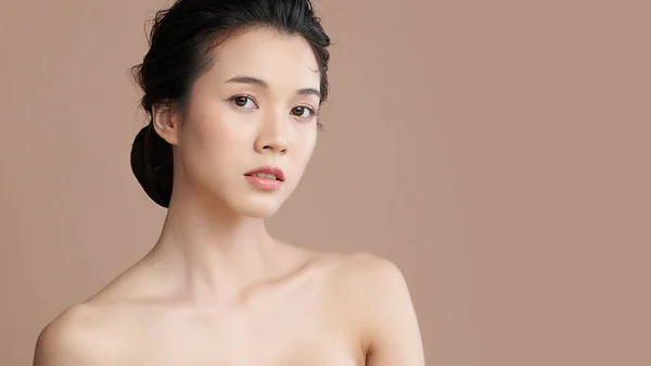 Beautiful young asian woman with clean fresh skin on beige background, Face care, Facial treatment, Cosmetology, beauty and spa, Asian women portrait.