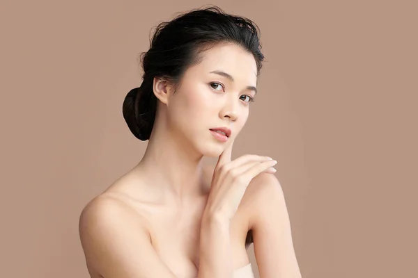 Beautiful young asian woman with clean fresh skin on beige background, Face care, Facial treatment, Cosmetology, beauty and spa, Asian women portrait.