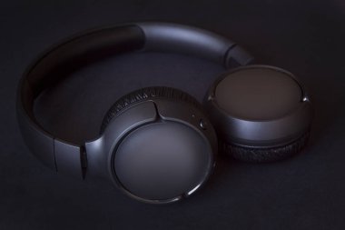 Bluetooth sistemi olan siyah kablosuz kulaklıklar, siyah desenli arka plan