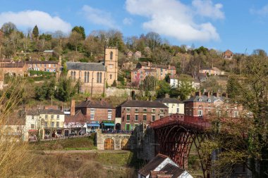 Shropshire, İngiltere 'deki Ironbridge' in yanı sıra St Lukes Kilisesi ve mavi gökyüzü gününde şehirdeki dükkanlar ve evler