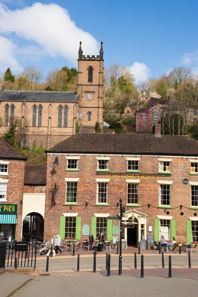 İngiltere 'nin Shropshire kentindeki Ironbridge kasabasındaki evler, dükkanlar ve St. Lukes Kilisesi' nin mavi gökyüzü günü manzarası