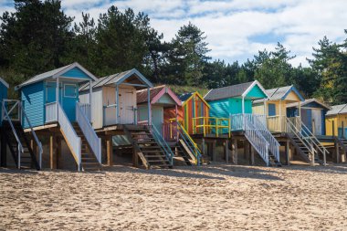 Wells 'te kumsalda renkli ahşap plaj kulübeleri Kuzey Norfolk, İngiltere' de The Sea Next