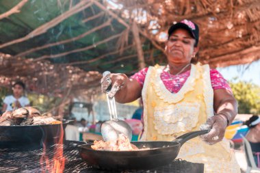 Yaşlı Latin kadın, Masachapa, Nikaragua sahilinde kızarmış balık pişiriyor. Latin Amerika 'daki yaşlı yetişkinlerin ticaret, iş ve faaliyet kavramı.