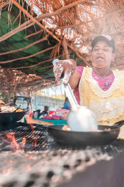 Masachapa, Nikaragua sahilinde kızarmış balık pişiren yaşlı bir Latin kadının karamsar fotoğrafı. Latin Amerika 'daki yaşlı yetişkinlerin ticaret, iş ve faaliyet kavramı.