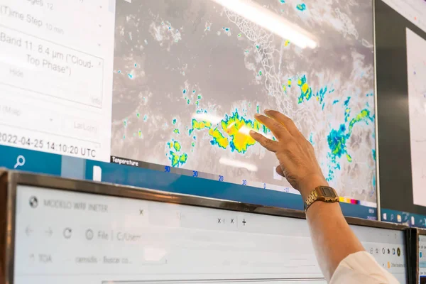 Meteoroloji uzmanının elinde bir ekrana yansıtılan grafiklerin haritasında hava tahmini yaparken..