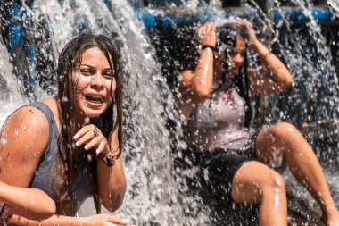 Orta Amerika, Nikaragua 'da Masachapa nehrinde bir barajın sularında yıkanan iki Latin kadın. Yaz tatilinde arkadaş eğlencesi kavramı