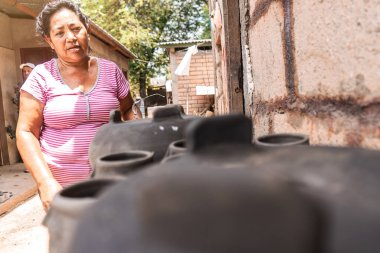 La Paz Centro, Nikaragua 'daki el sanatları atölyesinde güneşte kurumuş killeri kontrol eden bir zanaatkar. Latin Amerika 'nın yoksul ülkelerinde seyahat, kültür ve ekonomi kavramı.