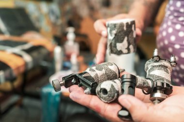 Elinde makine tutan Latin bir kadın dövme sanatçısının eli.