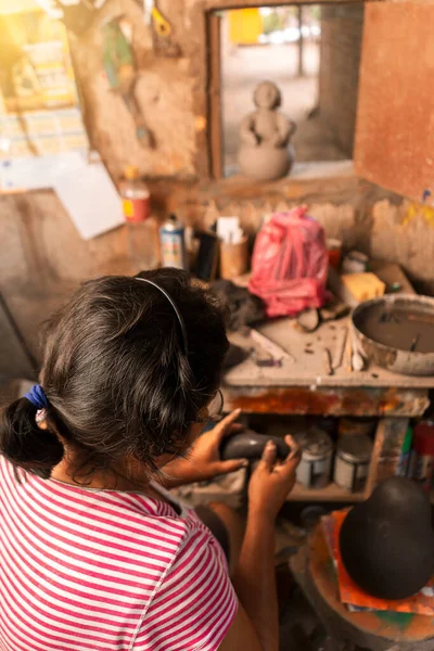 Vertical photo of an artisan from La Paz Centro Nicaragua molding a piece of clay