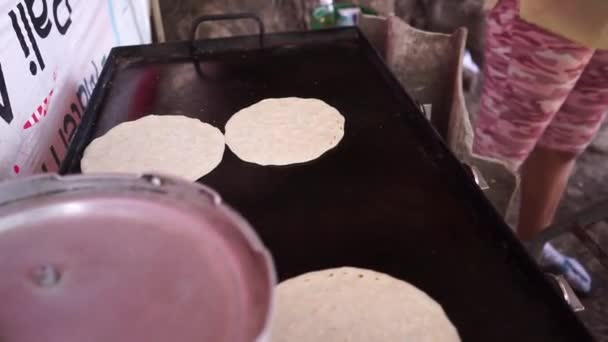 Mulheres cozinhando tortilhas de milho em uma grade de metal quente em uma rua na Nicarágua — Vídeo de Stock