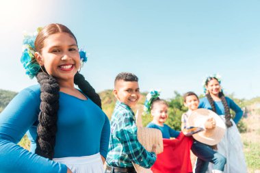 Nikaragua 'da bir dağda gülümseyen ve kameraya bakan geleneksel taşra kıyafetleri giymiş Latin gençlerden oluşan bir grup.