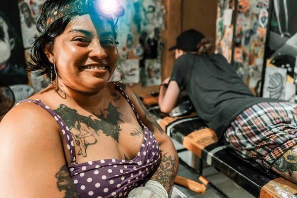 彼女のスタジオで彼女のカメラの前で笑顔の前にランプとラテンタトゥーアーティストマニカラグア — ストック写真