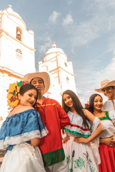 Teenagers from Nicaragua with traditional Latin American clothing with the cathedral church of Jinotega in the background