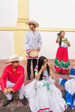 Vertical photo of Latino youth in traditional clothing outside a church in Jinotega Nicaragua