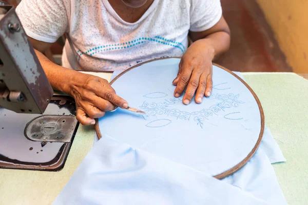 Aktif Latin büyükanne Guayabera tişörtüne nakış işliyor.