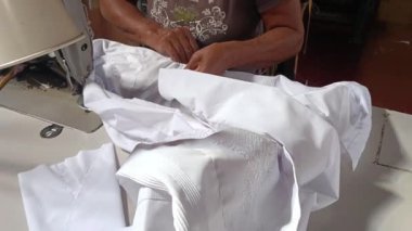Granada, Nikaragua 'da bir zanaatkar dikiş atölyesinde Guayabera gömleği diken tanınmamış Latin yaşlı kadın.