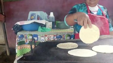 Nikaragua 'daki mütevazı evinde tortilla pişiren tanınmamış Latin kadın.