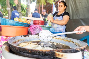 Latin Amerika 'da sokak yemekleri. Kızarmış enchilada hazırlayan kadın, Nikaragua 'dan geleneksel yemekler.