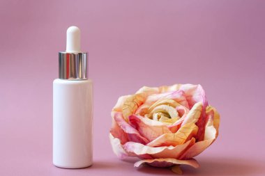 Pembe arka planda kozmetik şişesi