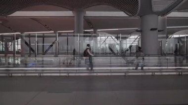 İstanbul havalimanı terminalin içinde, insanlar vardıktan sonra koridor boyunca yürüyorlar.