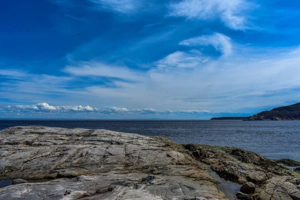 Nehre Tadoussac 'taki kayalardan ve mavi gökyüzünden bak, Quebec, Kanada
