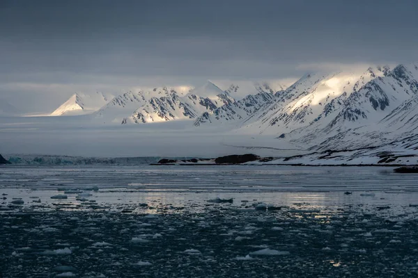 Montanhas nevadas com picos nas nuvens. Em Svalbard, Noruega. Aquecimento global. — Fotografia de Stock