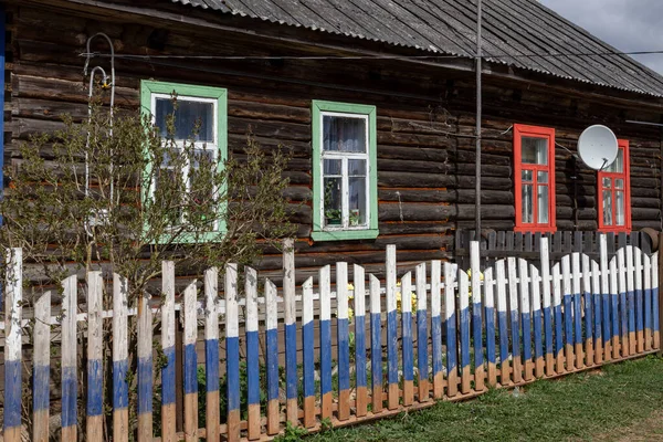 Lauga, Rus köyü. Eski kır evi. Rus bayrağı boyalı bir çit..