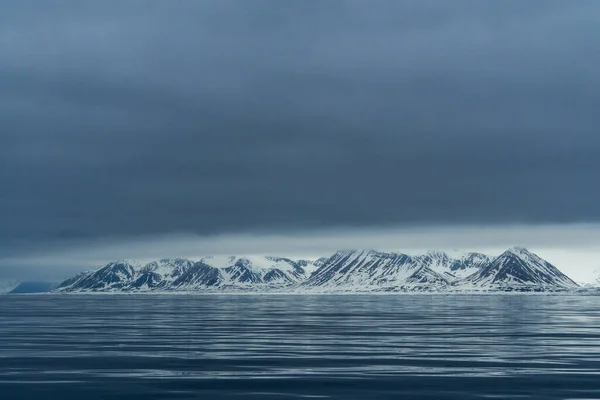 Panoramisch uitzicht op het blauwe uur van de bergen, sneeuw en zee in Spitsbergen, Noorwegen. — Stockfoto