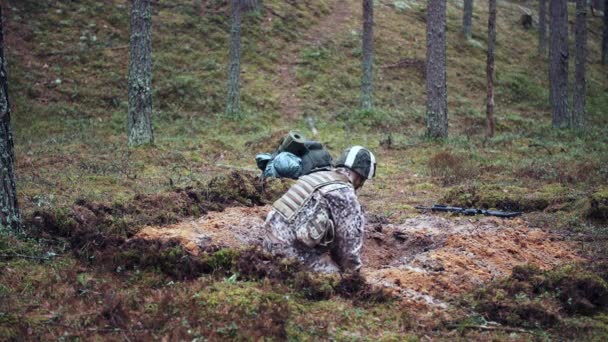 Jeden żołnierz kopie rów w sosnowym lesie. Przygotowania do ataku — Wideo stockowe
